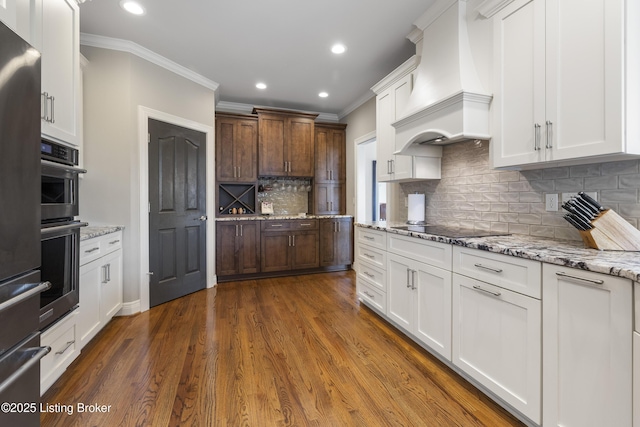 12206 Bridgeway Ct, Sellersburg, IN 47172 - kitchen with stainless steel oven, black electric cooktop, crown molding, and premium range hood