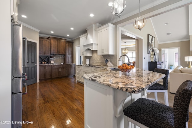 12206 Bridgeway Ct, Sellersburg, IN 47172 - kitchen with a chandelier, custom exhaust hood, a peninsula, ornamental molding, and a breakfast bar area