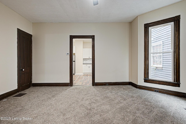 carpeted empty room featuring baseboards