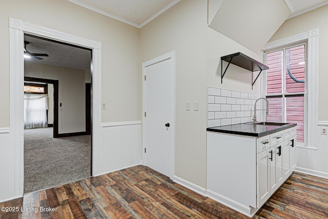 kitchen with a sink, open shelves, white cabinetry, dark countertops, and dark wood-type flooring