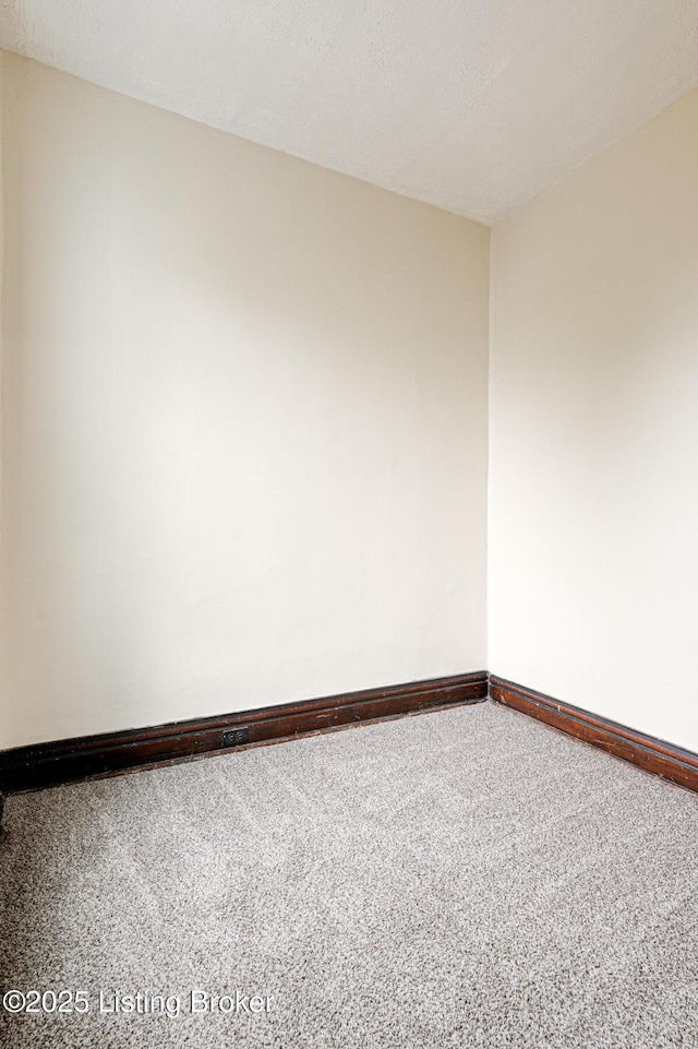 spare room with baseboards and a textured ceiling