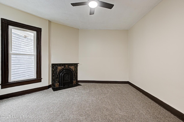 unfurnished living room with carpet flooring, a ceiling fan, baseboards, and a textured ceiling