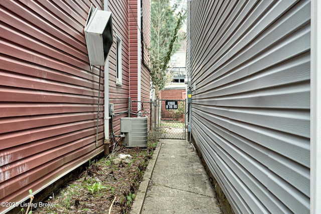 view of property exterior with cooling unit and a gate
