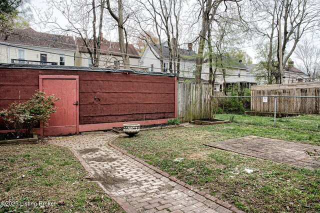 view of yard with fence and an outdoor structure