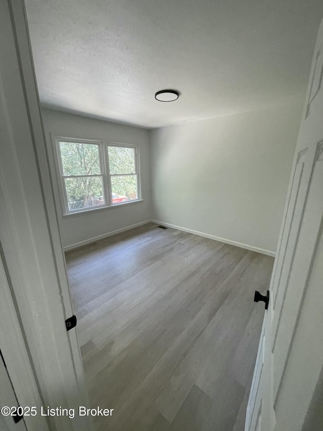 5001 Wabash Pl, Louisville, KY 40214 - unfurnished bedroom featuring baseboards, a textured ceiling, and wood finished floors