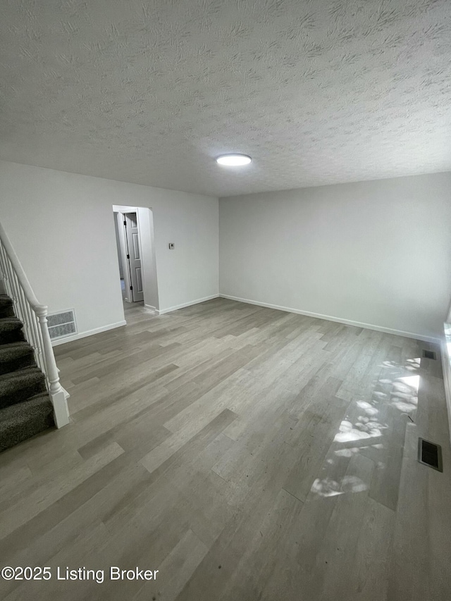 5001 Wabash Pl, Louisville, KY 40214 - empty room featuring stairs, visible vents, wood finished floors, and baseboards