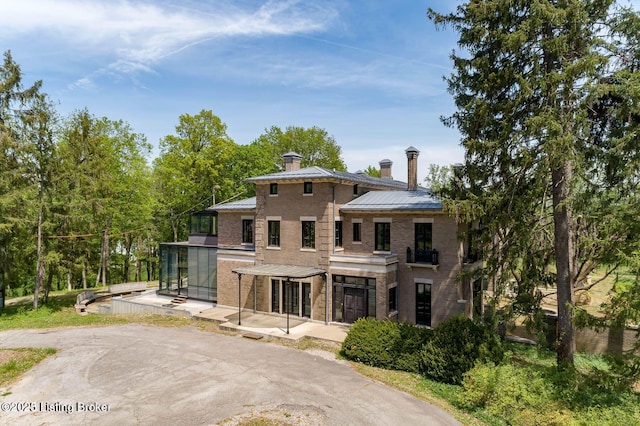 1801 Sulgrave Rd, Louisville, KY 40205 - view of front of home featuring a chimney, a standing seam roof, a patio area, and metal roof