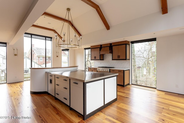 1801 Sulgrave Rd, Louisville, KY 40205 - kitchen with an island with sink, a sink, lofted ceiling with beams, tasteful backsplash, and light wood-type flooring