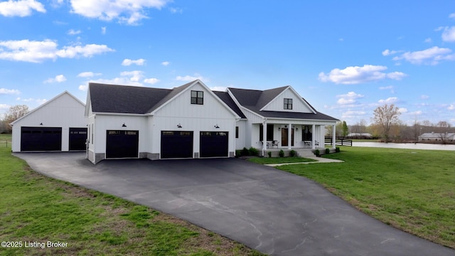 modern farmhouse with a front yard, a water view, a porch, aphalt driveway, and board and batten siding