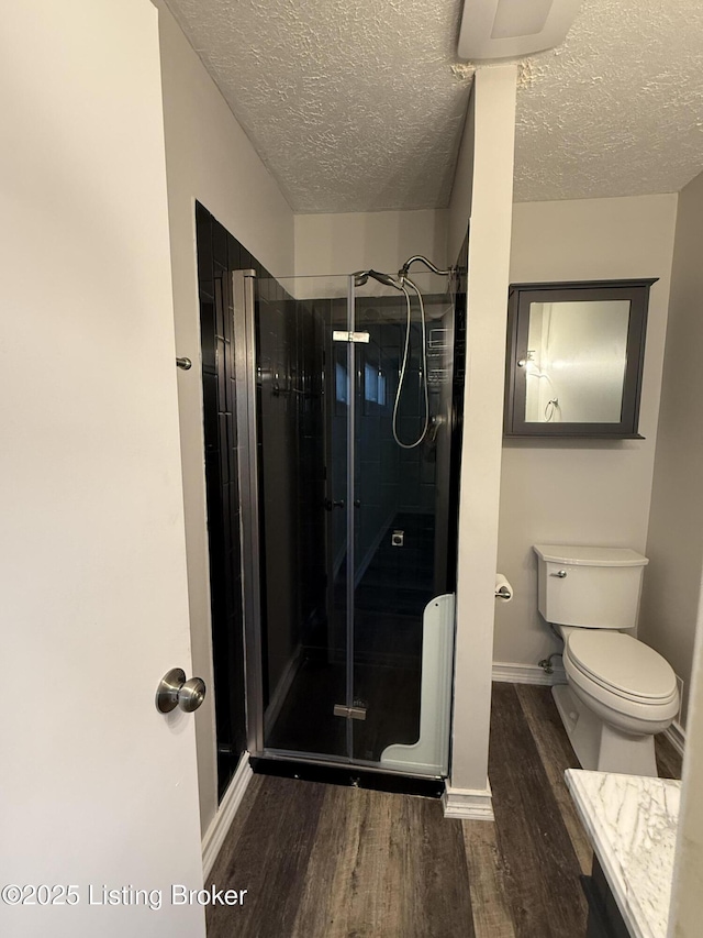 386 Pine Ridge Dr, Brandenburg, KY 40108 - full bathroom with a stall shower, toilet, wood finished floors, a textured ceiling, and baseboards