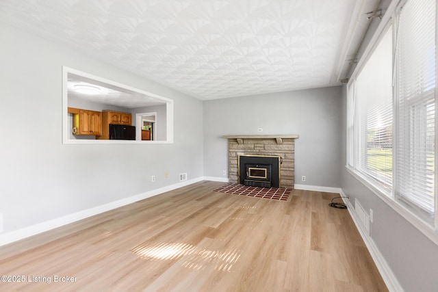 6515 Upper Hunters Trce, Louisville, KY 40216 - unfurnished living room featuring visible vents, a fireplace, baseboards, an ornate ceiling, and light wood-style floors