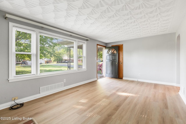 6515 Upper Hunters Trce, Louisville, KY 40216 - empty room with baseboards, arched walkways, light wood-type flooring, and visible vents