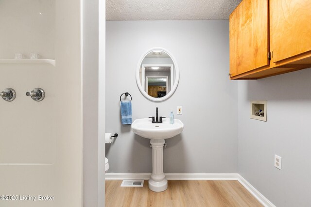 6515 Upper Hunters Trce, Louisville, KY 40216 - bathroom featuring visible vents, wood finished floors, toilet, baseboards, and a textured ceiling