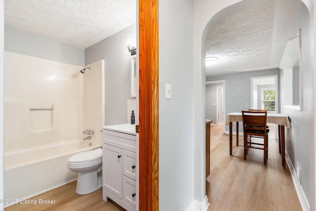 6515 Upper Hunters Trce, Louisville, KY 40216 - bathroom with vanity, wood finished floors, toilet, washtub / shower combination, and a textured ceiling