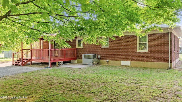 6515 Upper Hunters Trce, Louisville, KY 40216 - rear view of property featuring a lawn, a deck, a patio area, brick siding, and central AC