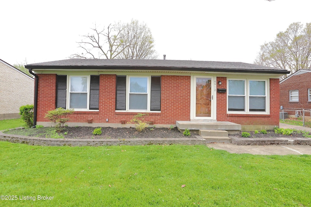 ranch-style home featuring brick siding, a front lawn, and fence