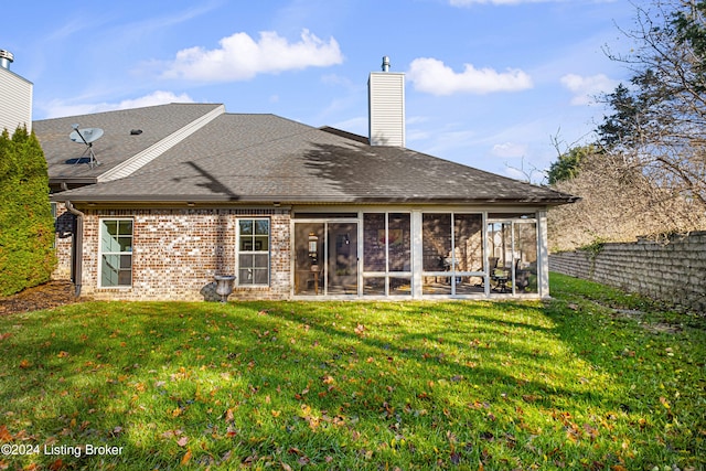 rear view of property with a sunroom, fence, a chimney, a lawn, and a shingled roof