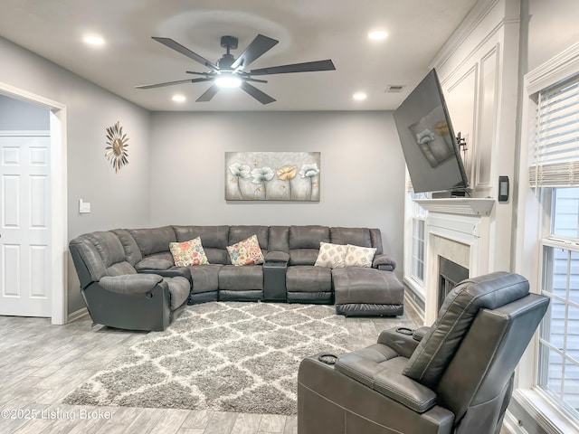 living area featuring a ceiling fan, wood finished floors, a fireplace, visible vents, and recessed lighting