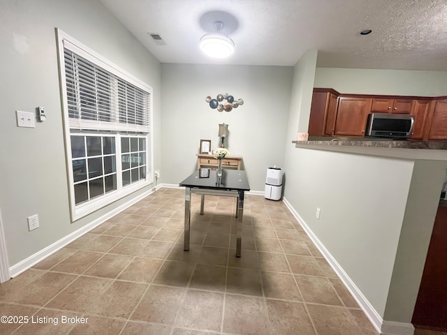 interior space featuring baseboards, light tile patterned flooring, and visible vents