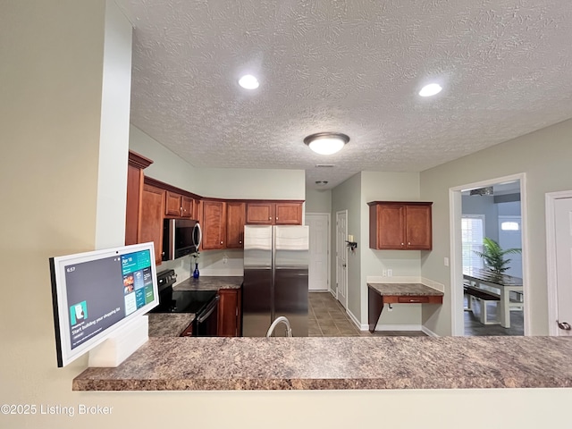 kitchen featuring baseboards, stainless steel appliances, a textured ceiling, and recessed lighting