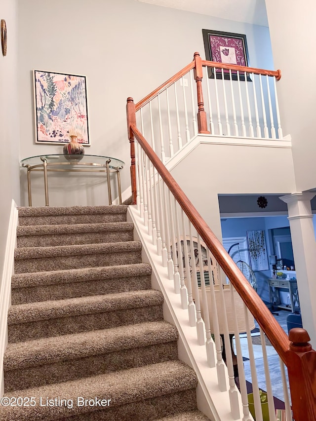 staircase with baseboards and decorative columns