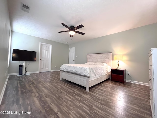 bedroom with baseboards, visible vents, ceiling fan, and dark wood finished floors