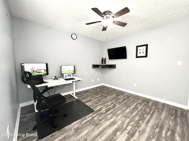 office area featuring a ceiling fan, baseboards, a textured ceiling, and dark wood finished floors