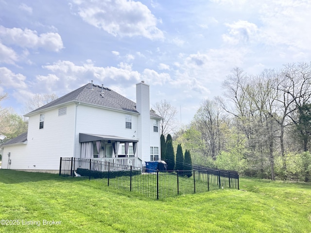 rear view of house featuring a lawn, fence private yard, and a chimney