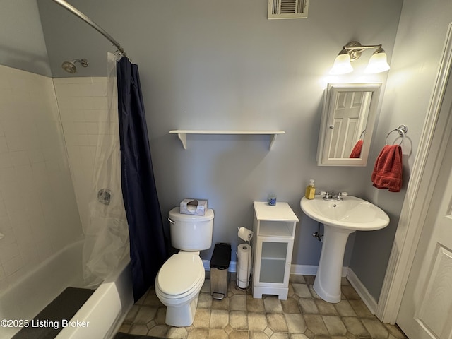 full bath with visible vents, baseboards, shower / bath combination with curtain, a sink, and toilet