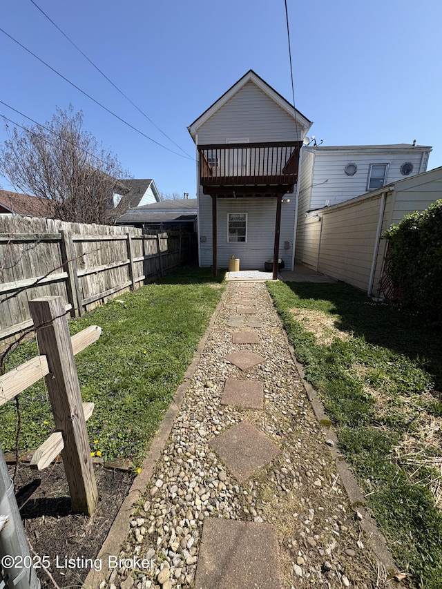 rear view of property with a yard and fence