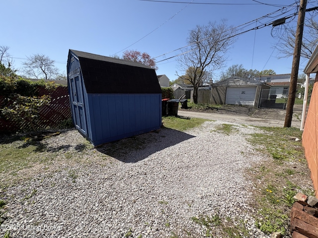 view of yard with an outbuilding, fence, a storage shed, and driveway