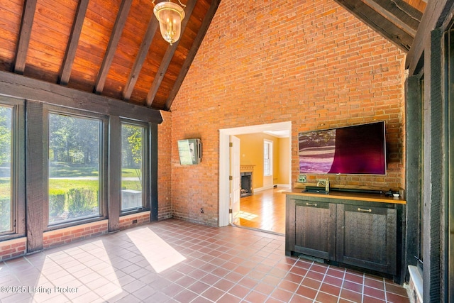 unfurnished living room featuring high vaulted ceiling, wooden ceiling, and a healthy amount of sunlight