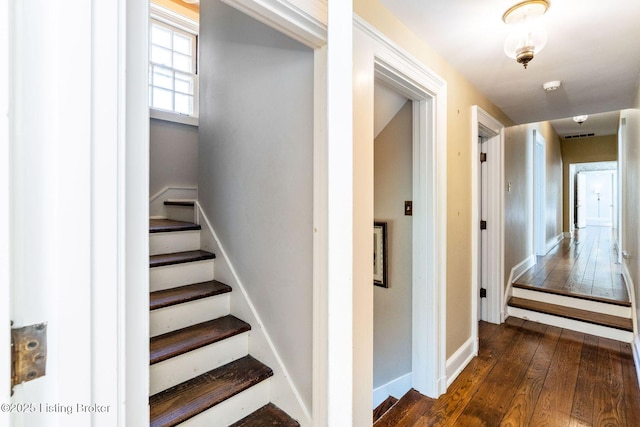 staircase featuring wood-type flooring and baseboards