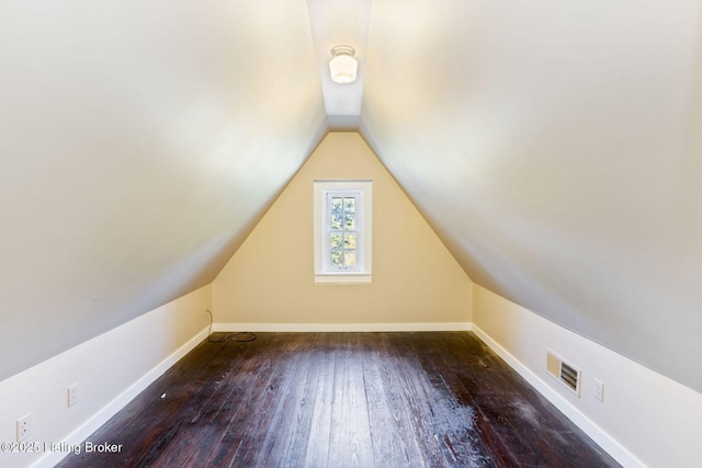 additional living space featuring visible vents, baseboards, hardwood / wood-style floors, and lofted ceiling