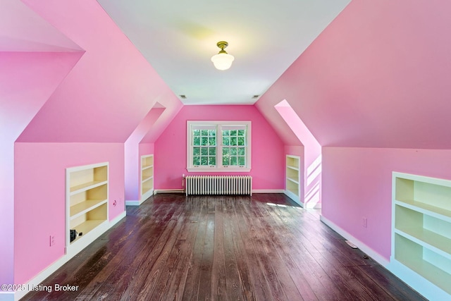 additional living space featuring baseboards, built in features, radiator heating unit, lofted ceiling, and wood-type flooring