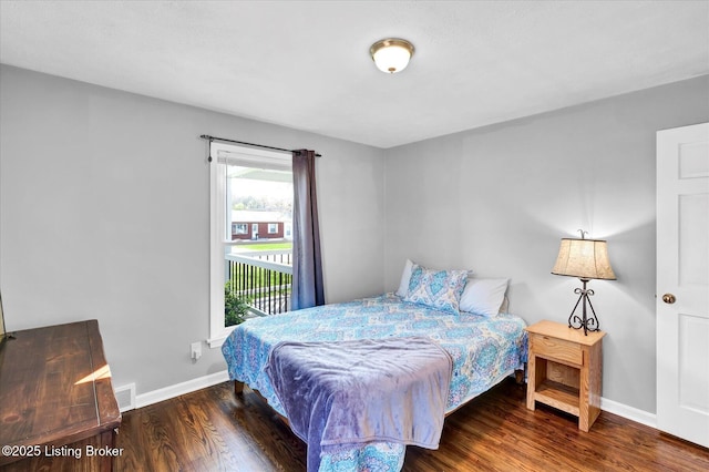 bedroom with access to exterior, wood finished floors, baseboards, and visible vents