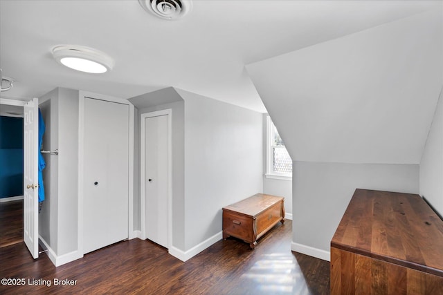 bonus room with baseboards, dark wood-style floors, visible vents, and lofted ceiling
