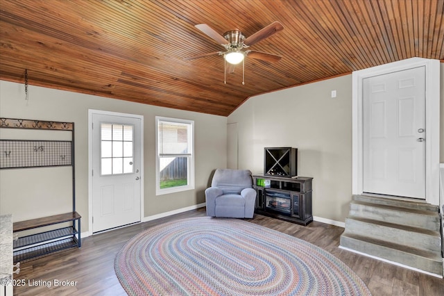 living area featuring lofted ceiling, baseboards, and wood finished floors