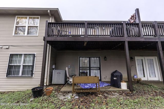 rear view of property with central air condition unit and a deck