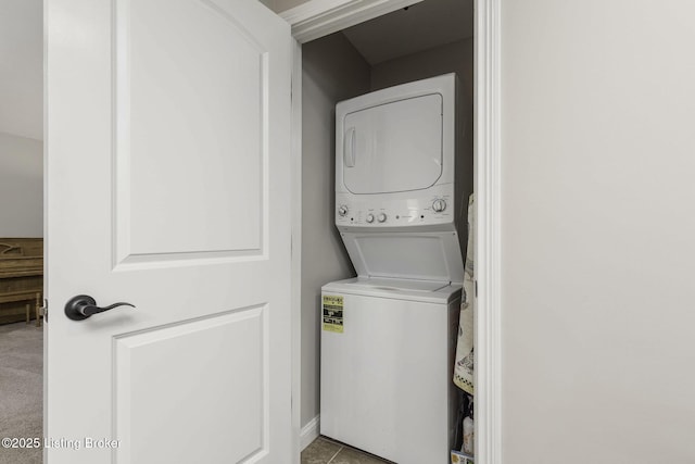 washroom with stacked washing maching and dryer and laundry area