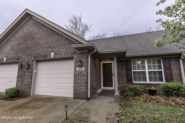 ranch-style home featuring an attached garage, brick siding, concrete driveway, and roof with shingles