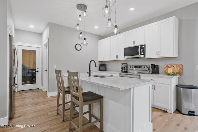3965 Broadford Rd, Clarkson, KY 42726 - kitchen featuring white cabinets, light wood finished floors, appliances with stainless steel finishes, an island with sink, and a sink