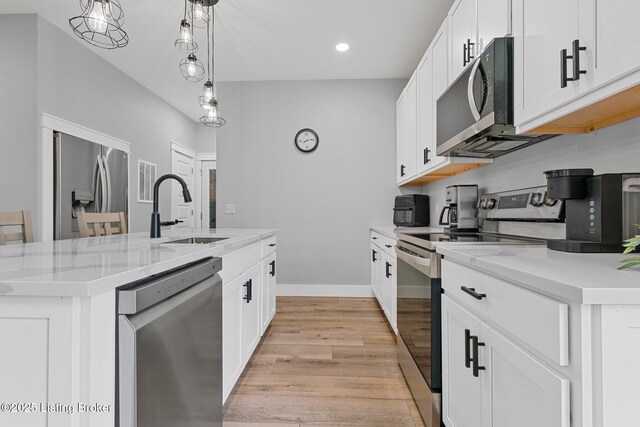 3965 Broadford Rd, Clarkson, KY 42726 - kitchen featuring appliances with stainless steel finishes, white cabinetry, an island with sink, a sink, and light wood-type flooring