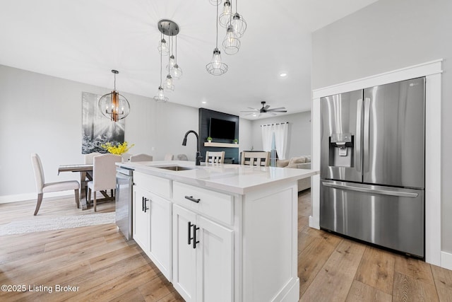 3965 Broadford Rd, Clarkson, KY 42726 - kitchen with ceiling fan with notable chandelier, a sink, light wood-style floors, pendant lighting, and appliances with stainless steel finishes