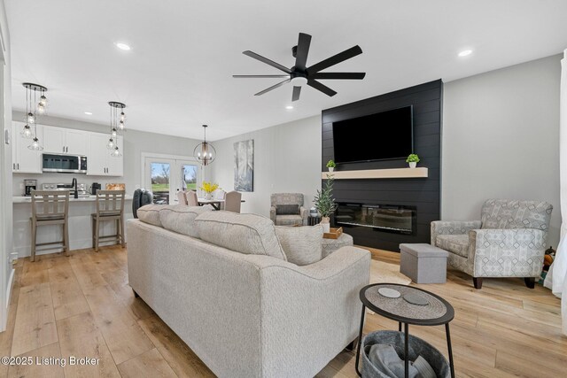 3965 Broadford Rd, Clarkson, KY 42726 - living area featuring a fireplace, light wood-style flooring, recessed lighting, and ceiling fan with notable chandelier