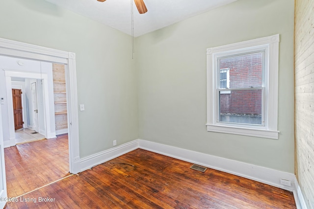 spare room featuring visible vents, ceiling fan, hardwood / wood-style floors, and baseboards