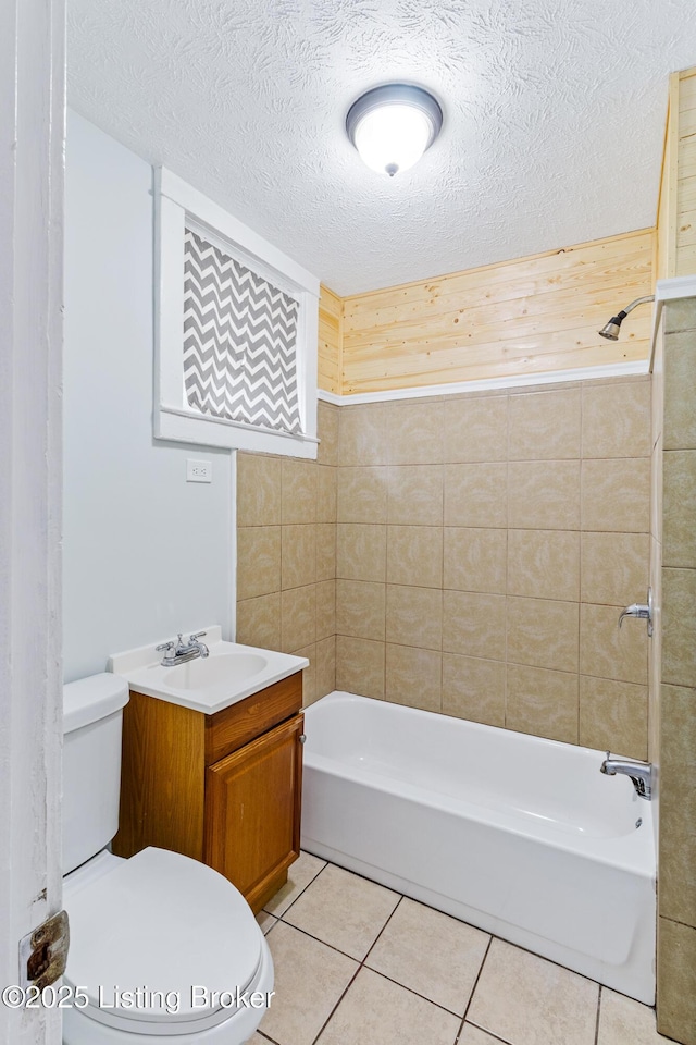 full bath with shower / bathtub combination, a textured ceiling, vanity, tile patterned flooring, and toilet
