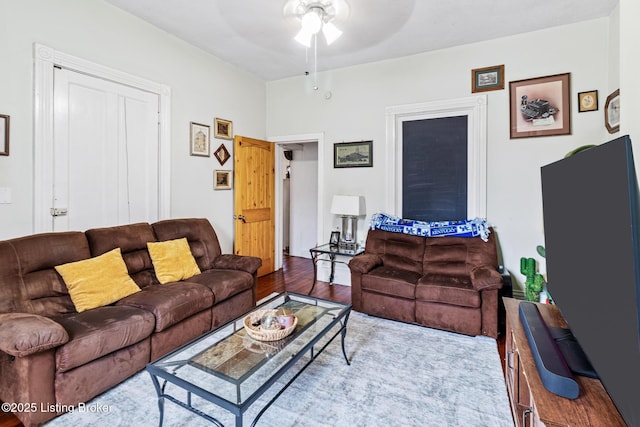 living area with a ceiling fan and wood finished floors