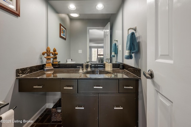 bathroom with baseboards, recessed lighting, and vanity