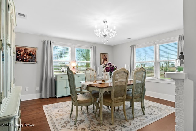 dining area featuring visible vents, baseboards, an inviting chandelier, and dark wood-style floors